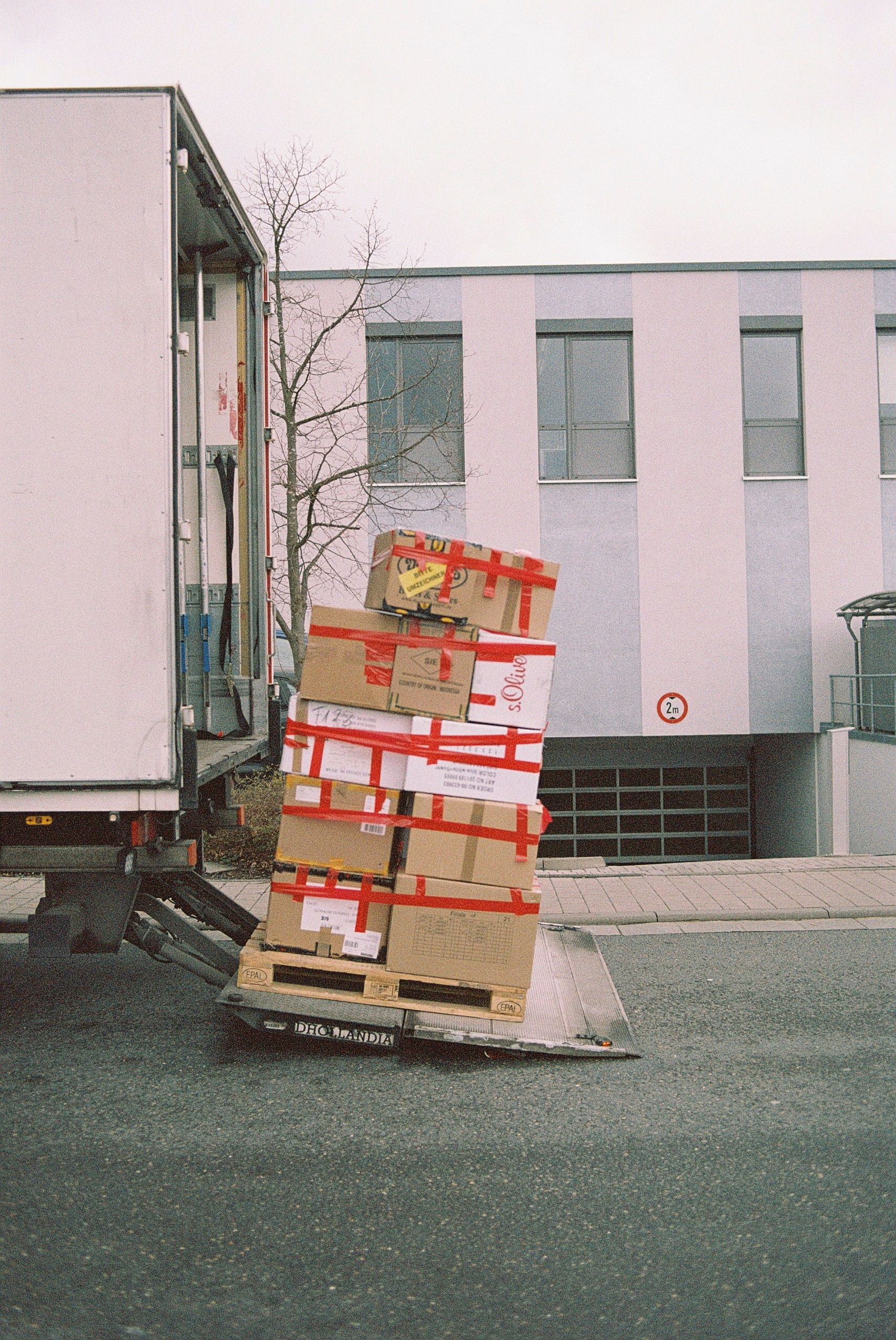 Brown cardboard boxes stacked on a pallet near the back of a truck